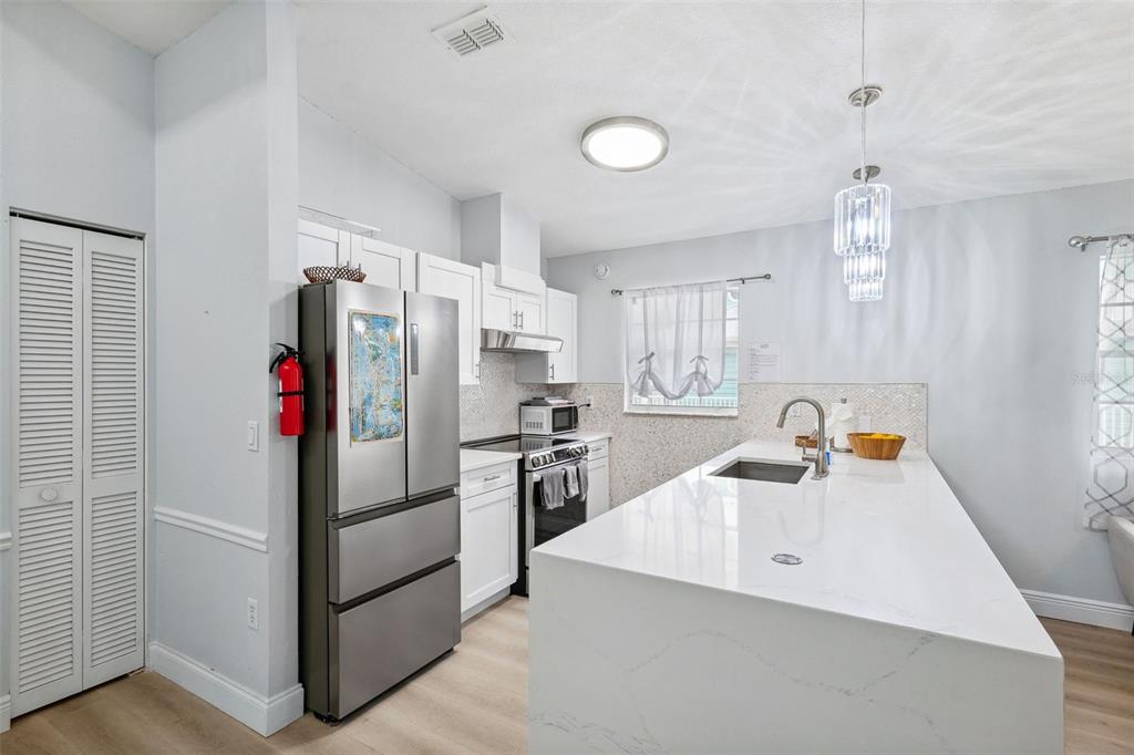 311 Poinsettia Road Anna Maria, FL 34216 - Photo 10 of 36 a kitchen that has a refrigerator and a sink