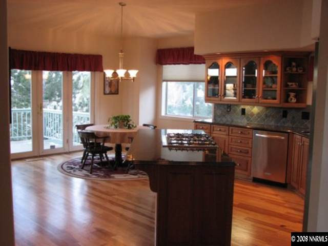 45 Rimfire Circle Reno, NV 89519 - Photo 5 of 9 a kitchen with granite countertop a stove dining table chairs and a large window
