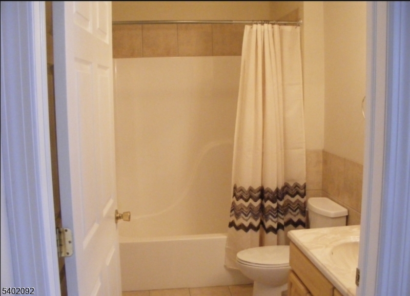 512 Chestnut Street, Unit E Union, NJ 07083 - Photo 2 of 5 a bath room with a toilet and a shower curtain