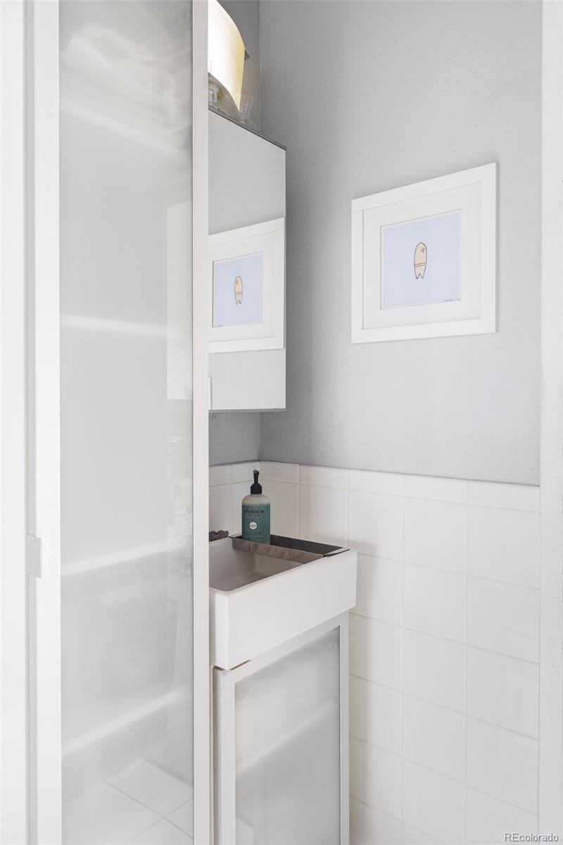 3309 Blake Street, Unit 207 Denver, CO 80205 - Photo 13 of 14 a bathroom with a sink and a mirror