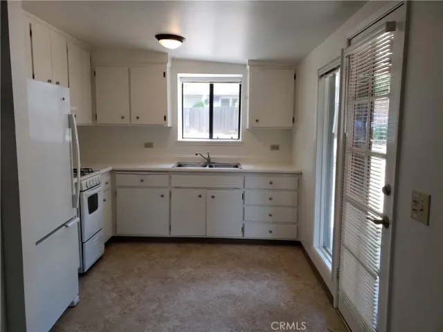 a kitchen with white cabinets and white appliances