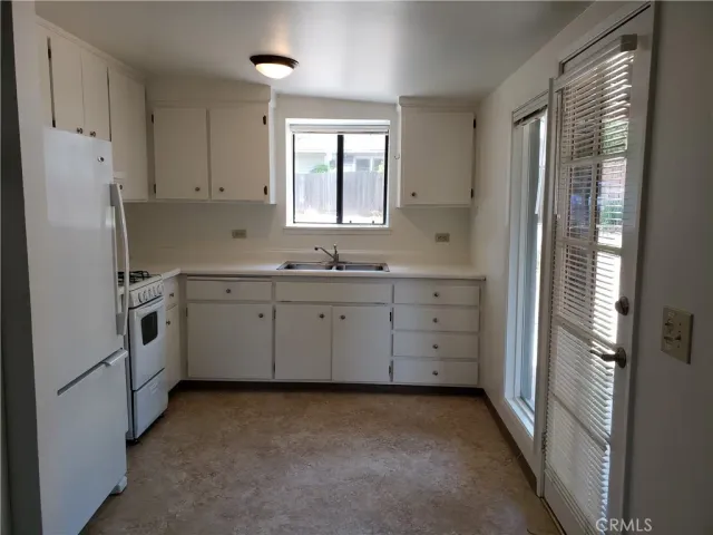 a kitchen with white cabinets and white appliances