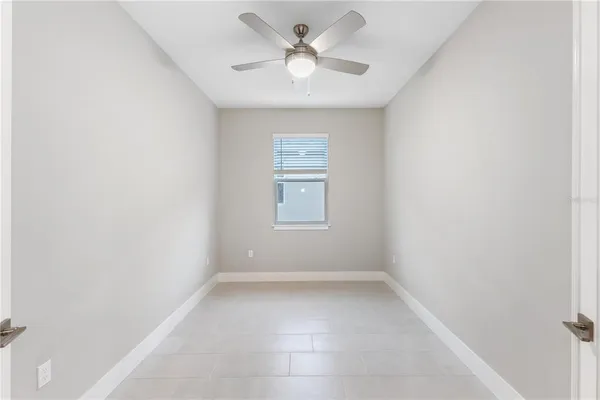 an empty room with a window and a fan