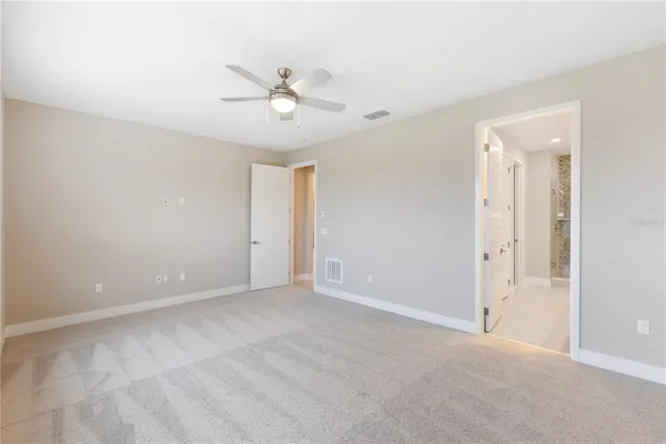a view of an empty room with a ceiling fan