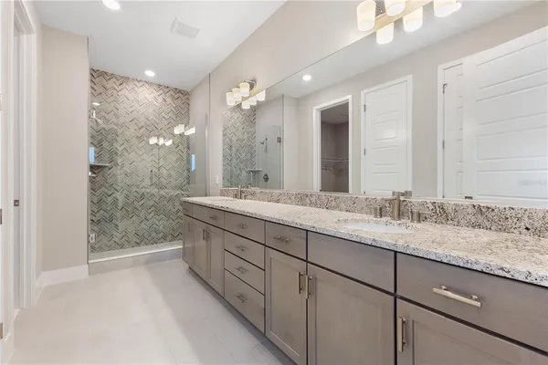 a bathroom with double sink and a mirror