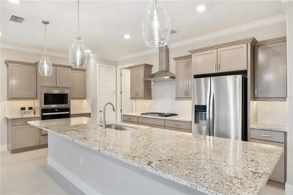 a kitchen with stainless steel appliances granite countertop a sink refrigerator and microwave
