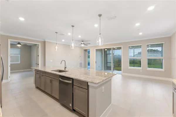 a large kitchen with kitchen island a large window a sink and stainless steel appliances