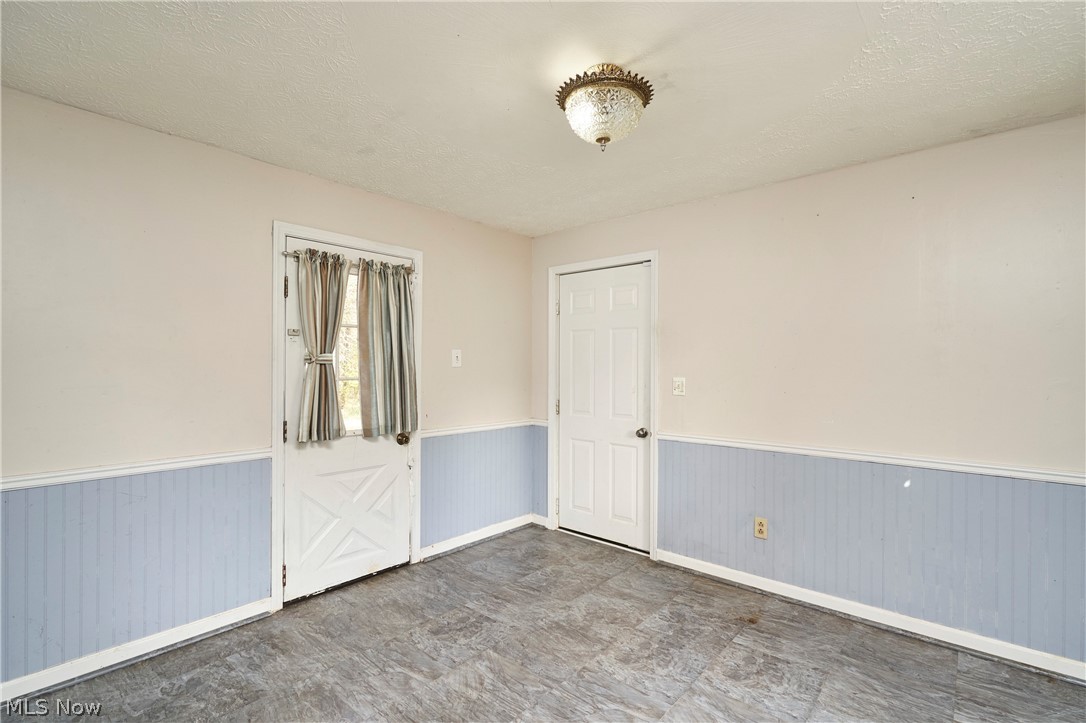 2941 Sweitzer Road Uniontown, OH 44685 - Photo 8 of 16 Unfurnished room with a textured ceiling and wainscoting