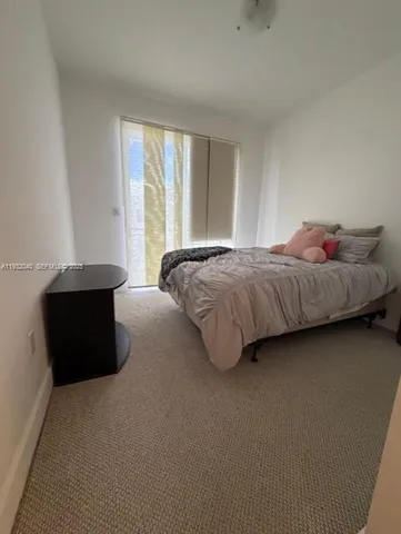 a living room with a bed and a large window