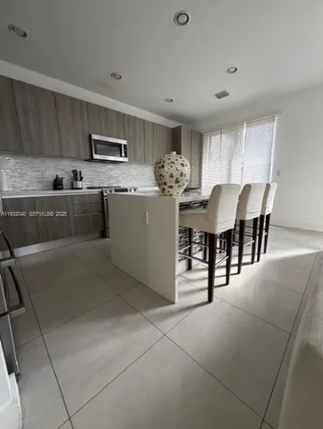a kitchen with stainless steel appliances kitchen island granite countertop a sink and cabinets