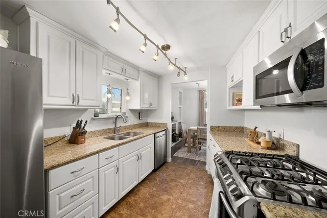 a kitchen with stainless steel appliances granite countertop a stove a sink and a microwave