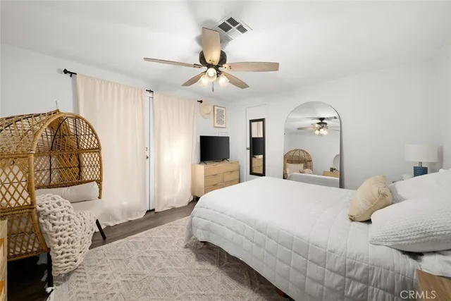 a bedroom with a large bed and a chandelier