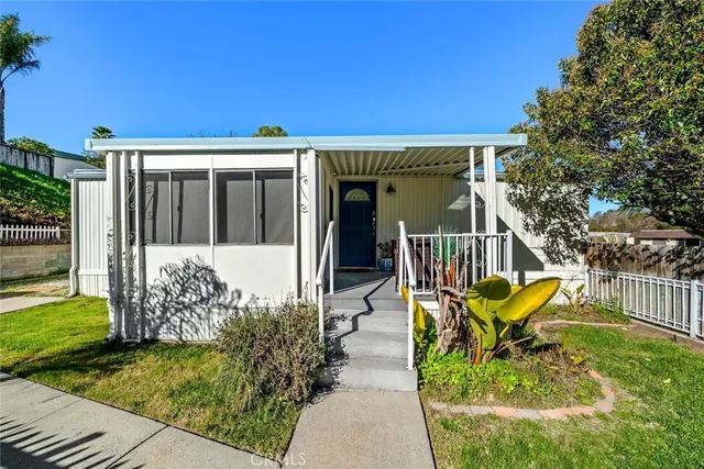 a view of a house with backyard and sitting area