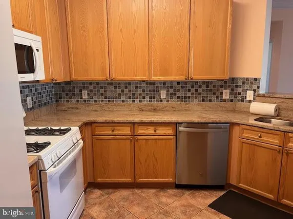a kitchen with granite countertop a sink stove and microwave
