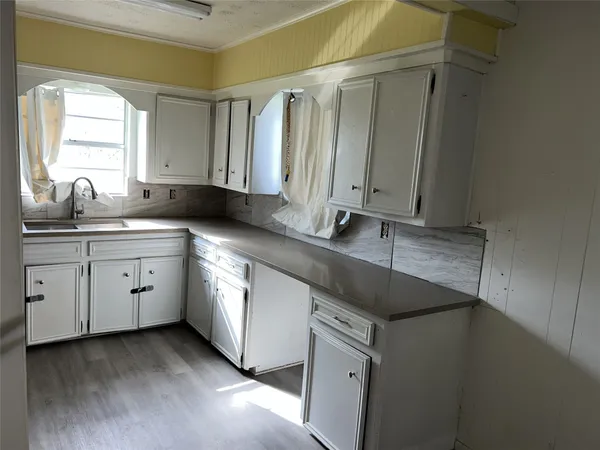 a kitchen with a sink dishwasher and cabinets