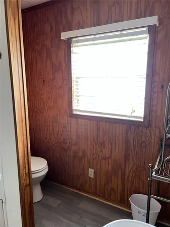 a bathroom with a toilet a sink and a window