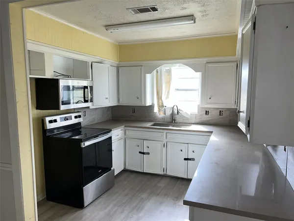 a kitchen with a sink stove and microwave