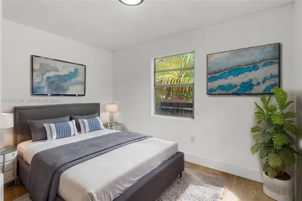a bedroom with a bed and a painting on the wall