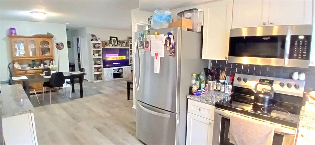 9643 Marlinton Lane Port Richey, FL 34668 - Photo 16 of 31 a kitchen with stainless steel appliances granite countertop a refrigerator and a stove