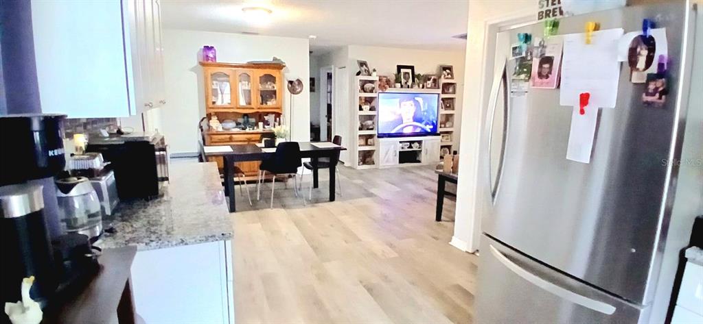 9643 Marlinton Lane Port Richey, FL 34668 - Photo 17 of 31 a living room with dining area and a refrigerator