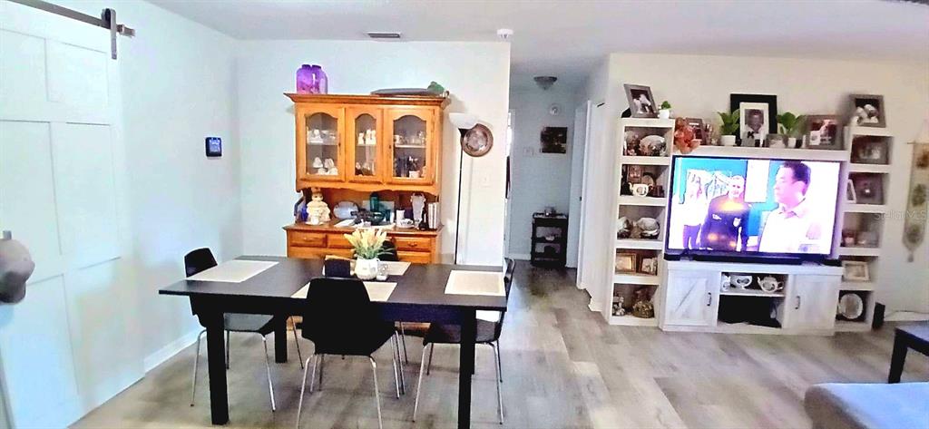 9643 Marlinton Lane Port Richey, FL 34668 - Photo 19 of 31 a view of a dining room with furniture wooden floor and a kitchen view