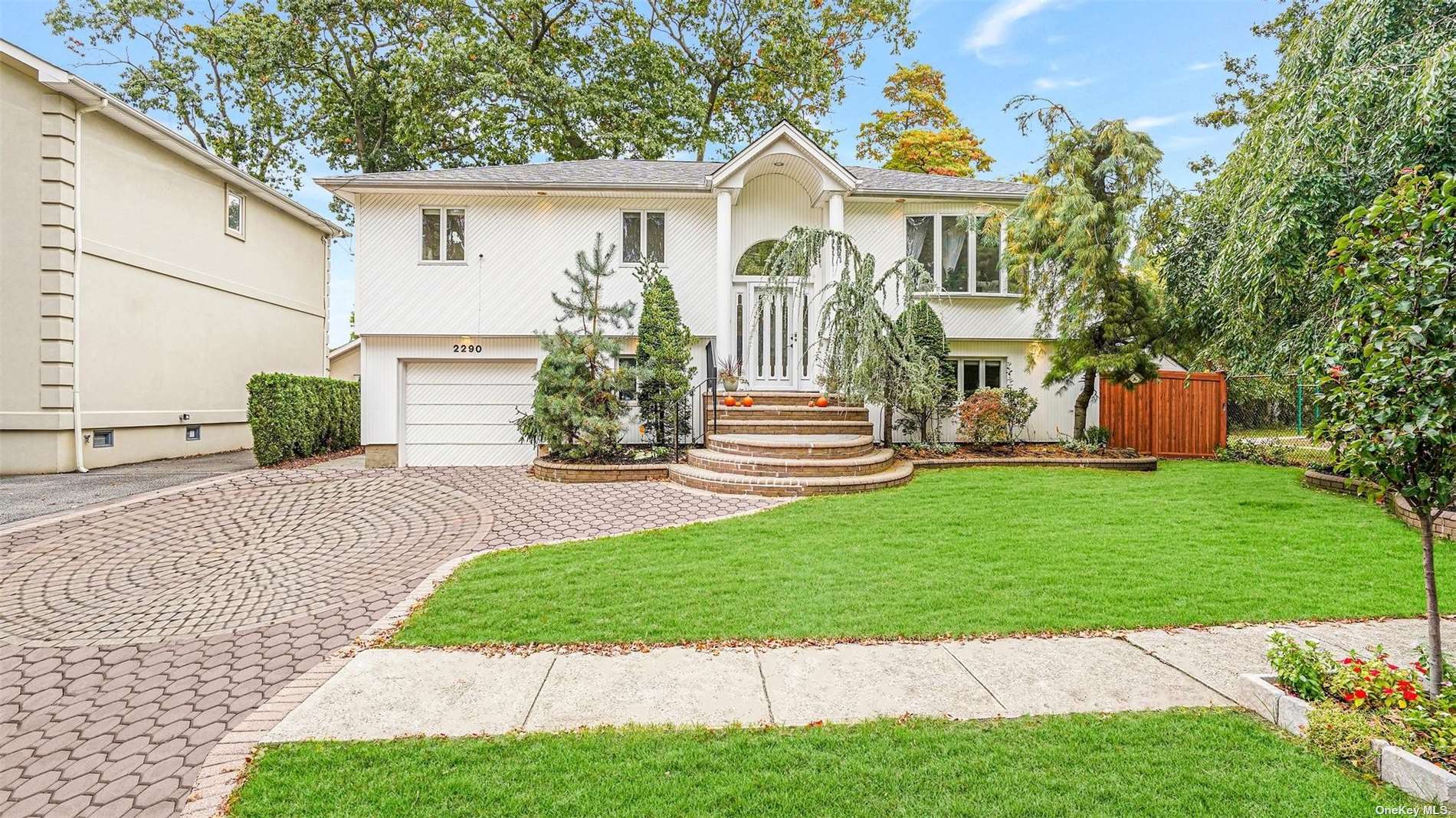 a front view of a house with a yard and trees
