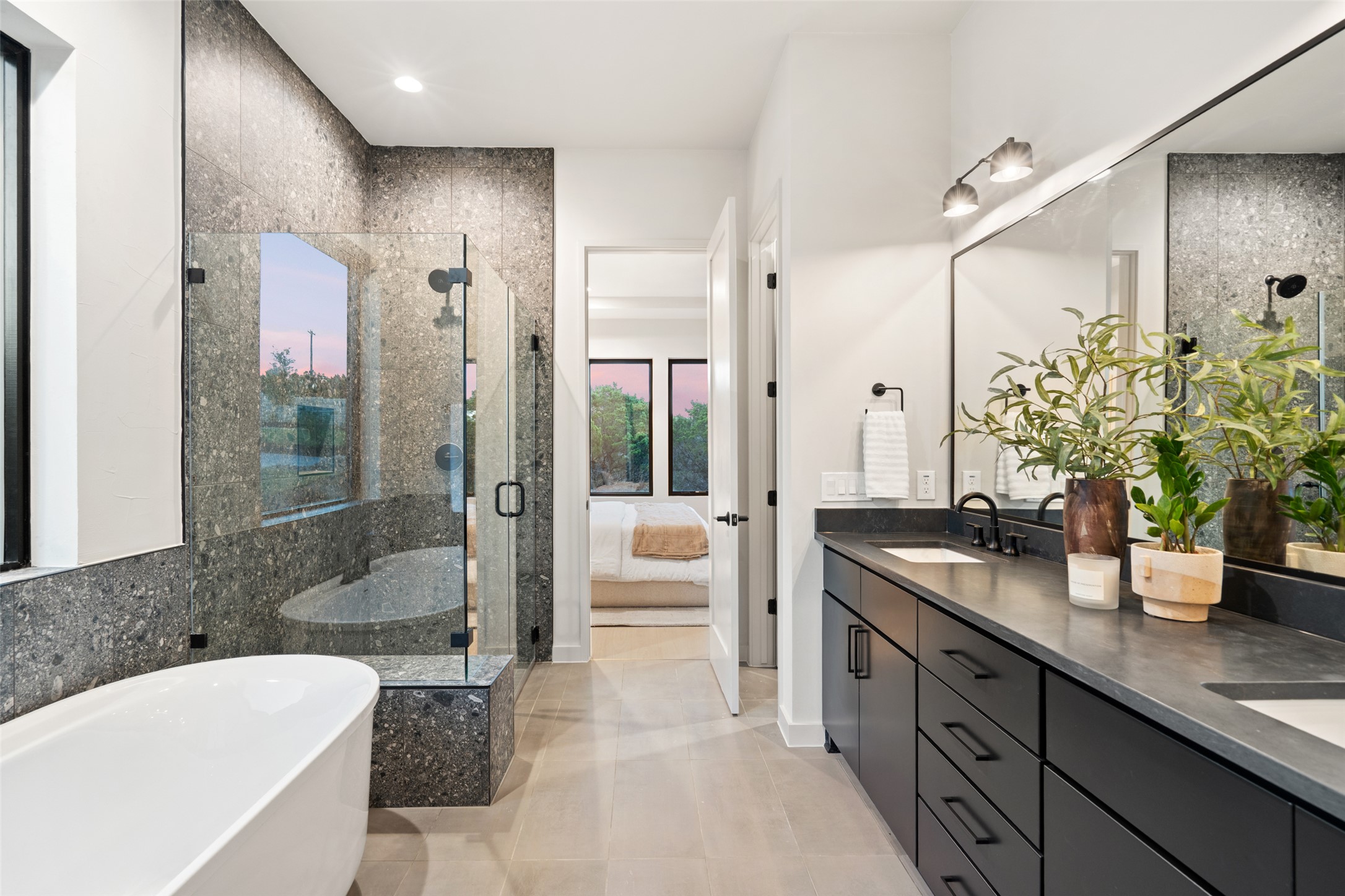 9803 Ribelin Ranch Court, Unit 6 Austin, TX 78750 - Photo 10 of 31 A spacious primary bathroom boasts a freestanding tub, glass-enclosed shower, and a wide double vanity.