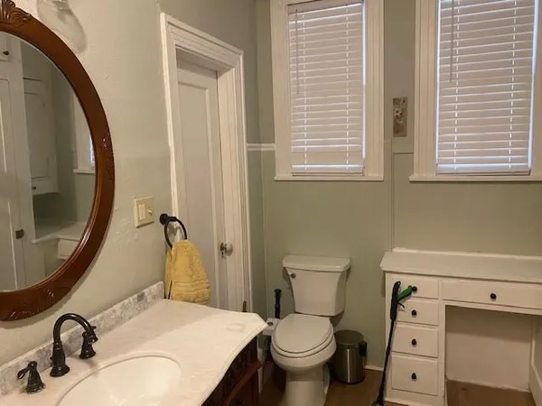 a bathroom with a sink a toilet and a mirror