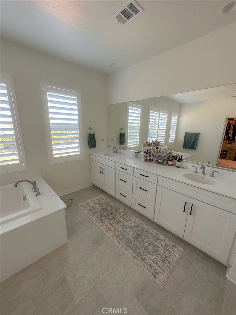 39547 Verbena Way Temecula, CA 92591 - Photo 11 of 31 a spacious bathroom with double vanity sink a bathtub and window
