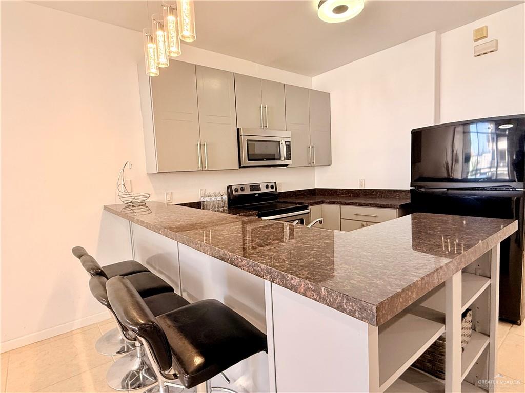 813 Travis Street, Unit 207 Mission, TX 78572 - Photo 14 of 38 a kitchen with a stove a sink and a microwave