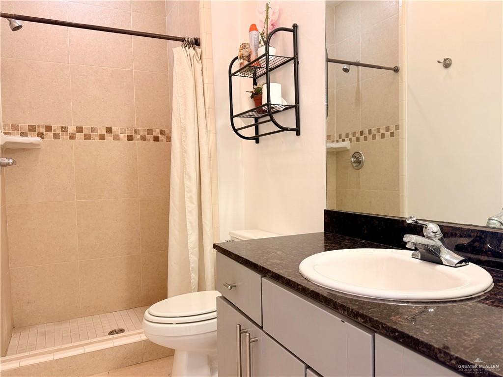 813 Travis Street, Unit 207 Mission, TX 78572 - Photo 19 of 38 a bathroom with a sink a toilet and shower