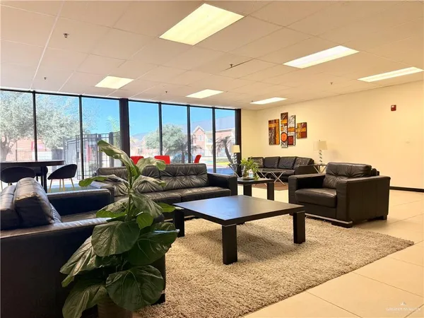 a living room with furniture a rug and white walls