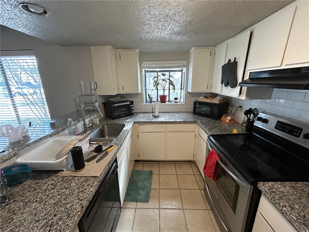 1500 Lemon Tree Lane College Station, TX 77840 - Photo 6 of 17 a kitchen with a sink stove top oven and cabinets