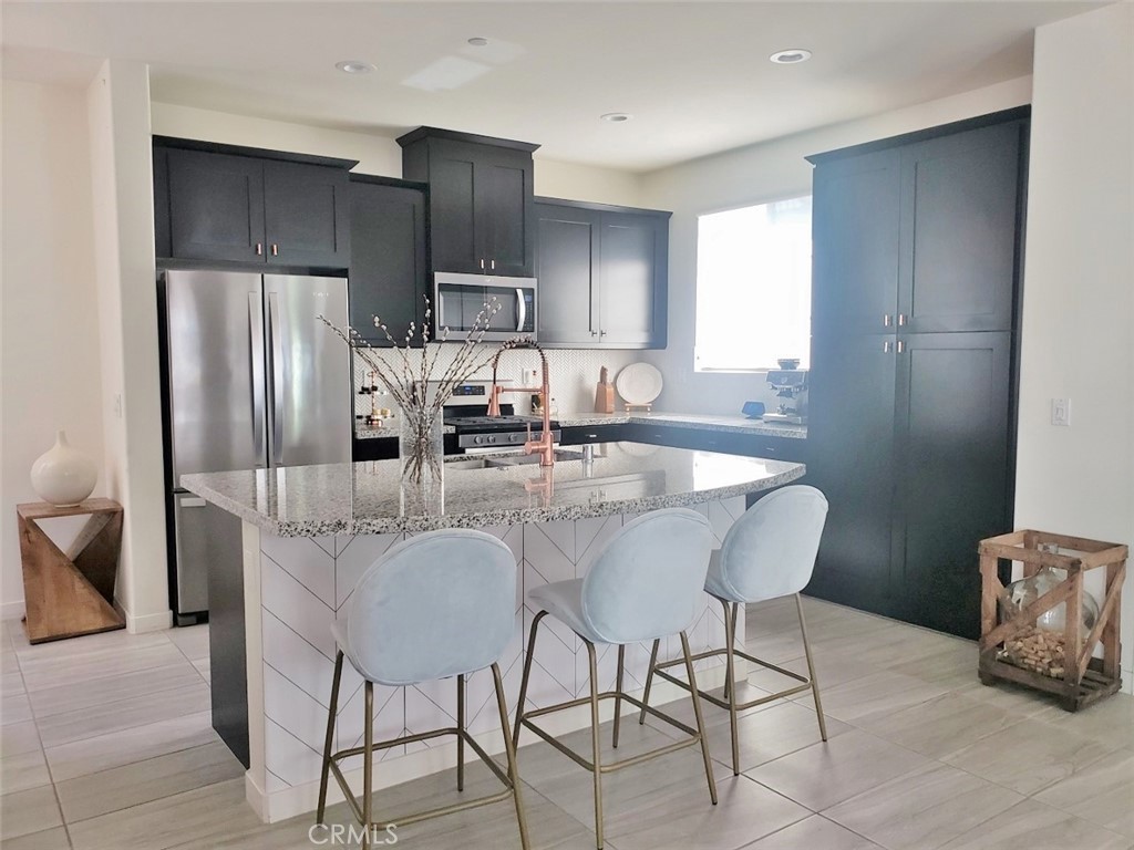 4120 Mission Tree Way Oceanside, CA 92057 - Photo 12 of 56 a kitchen with stainless steel appliances granite countertop a refrigerator and a stove top oven