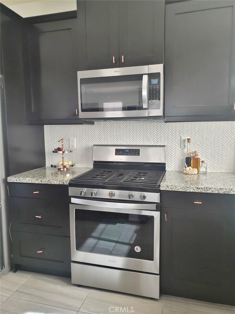 4120 Mission Tree Way Oceanside, CA 92057 - Photo 14 of 56 a stove top oven sitting inside of a kitchen and granite counter tops