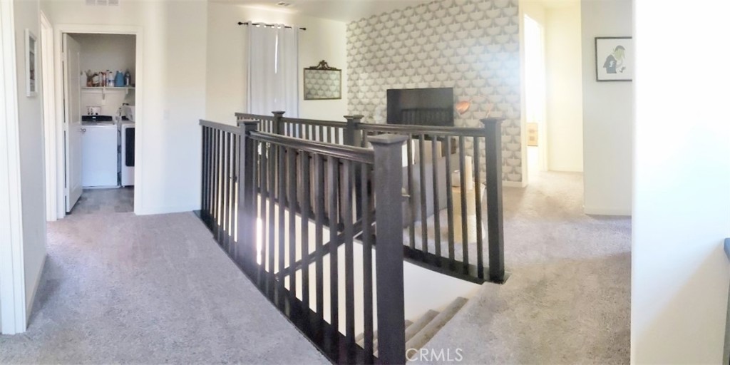 4120 Mission Tree Way Oceanside, CA 92057 - Photo 20 of 56 a view of a hallway with wooden floor and a flat screen tv
