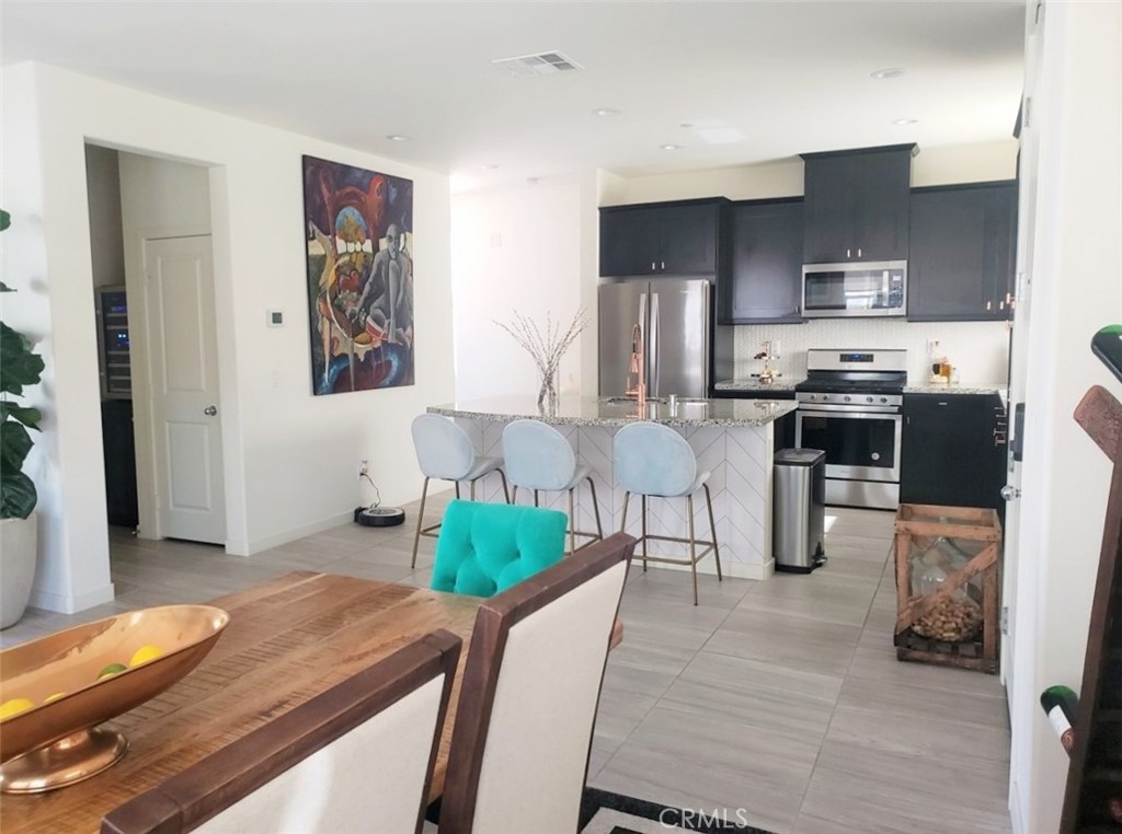 4120 Mission Tree Way Oceanside, CA 92057 - Photo 4 of 56 a living room with stainless steel appliances furniture a rug and a kitchen view