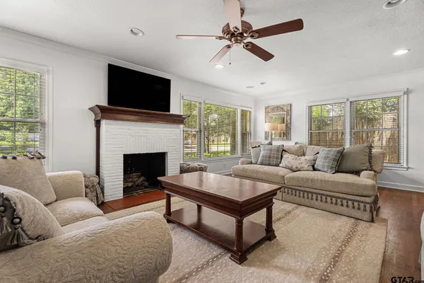 a living room with furniture a flat screen tv and a fireplace