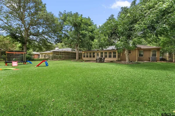an aerial view of residential houses with outdoor space and trees