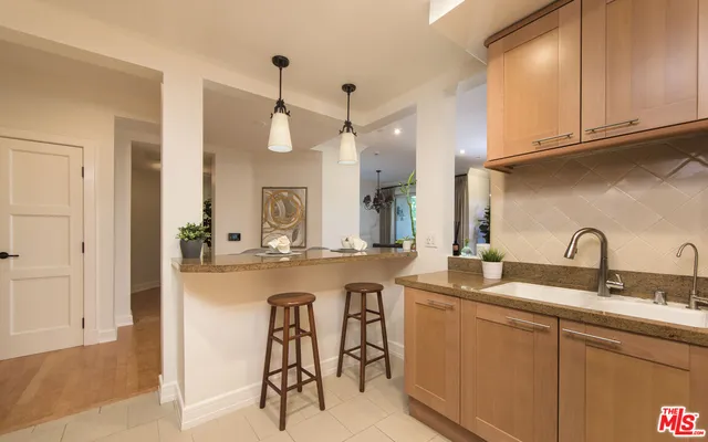 a kitchen with sink a microwave and cabinets