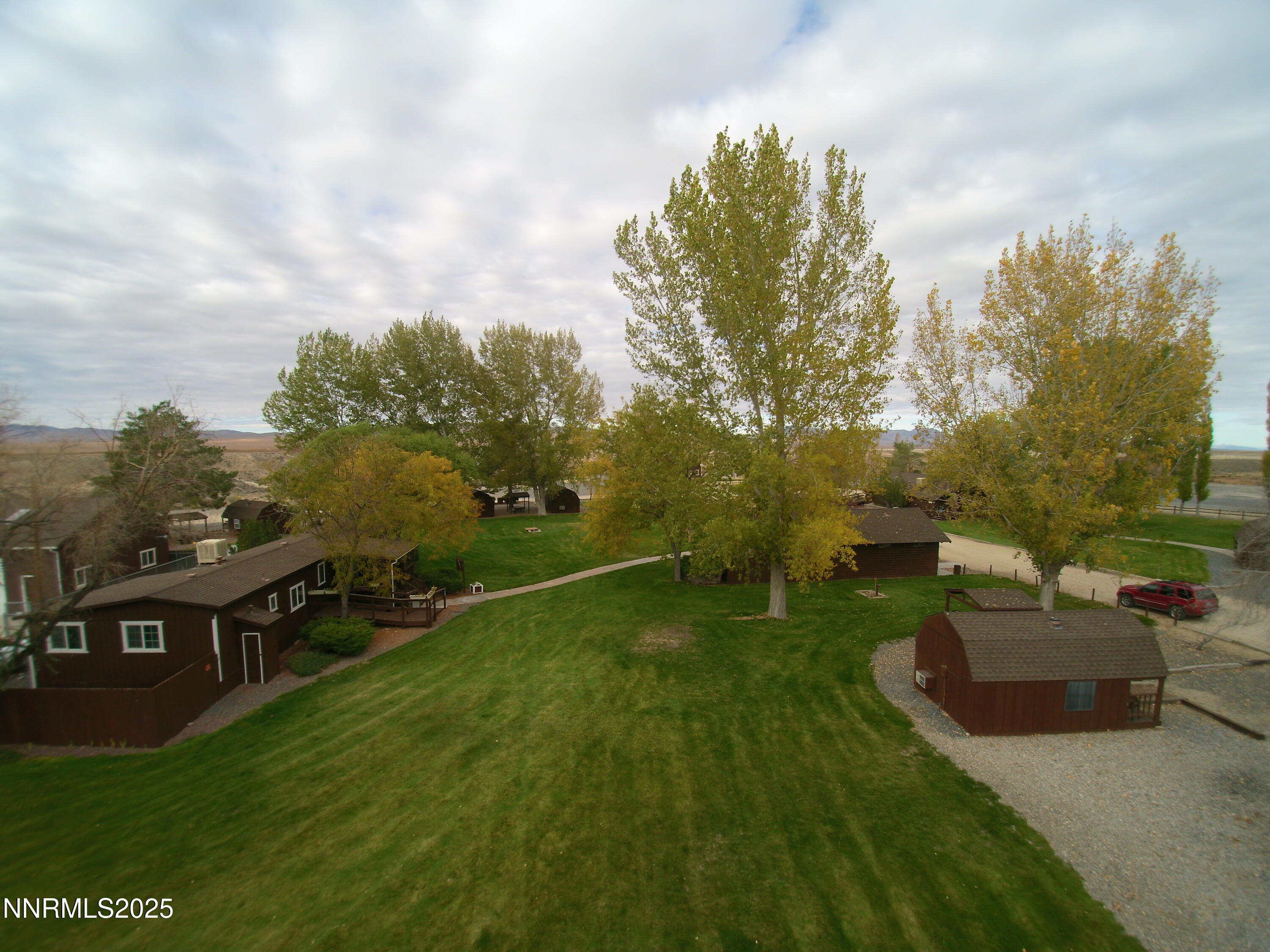 25055 Ramsey Road, Unit 31 Imlay, NV 89418 - Photo 24 of 26 a view of a garden with a bench in front of the house