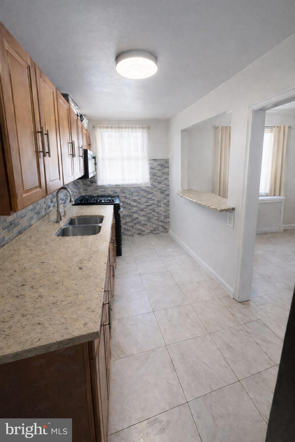 1305 Robbins Street Philadelphia, PA 19111 - Photo 6 of 19 a kitchen with granite countertop a sink and a stove