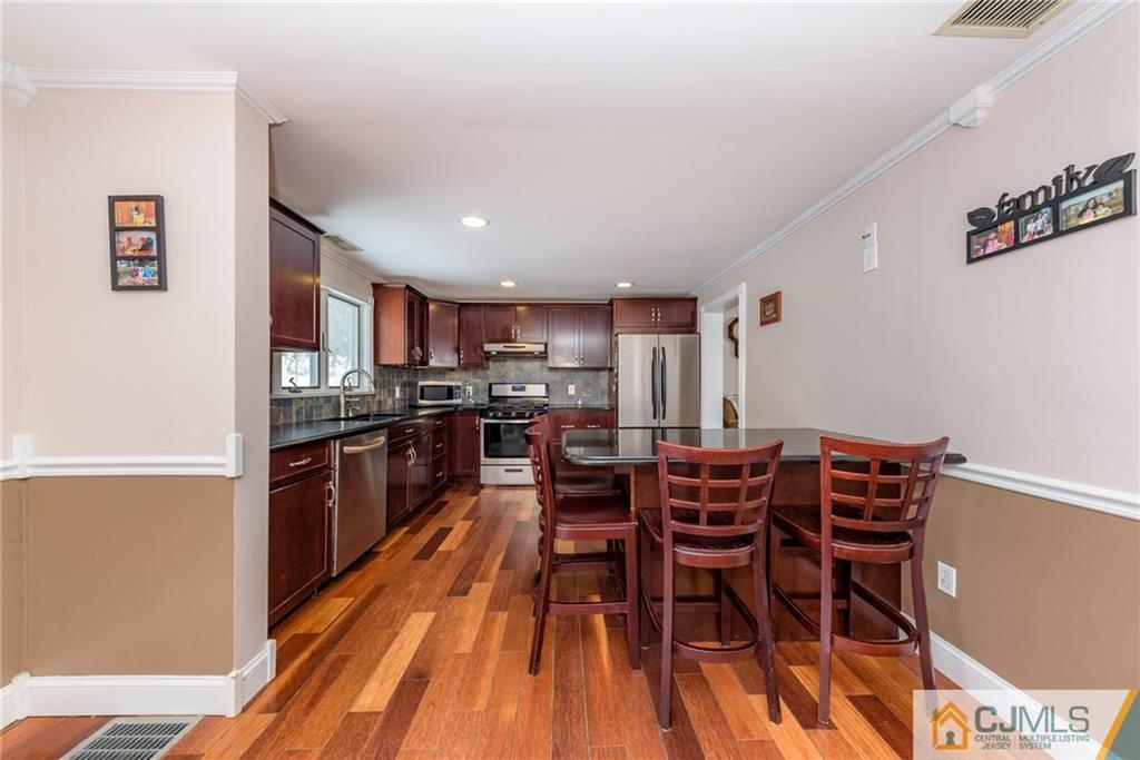 148 Rolling Ridge Road West Milford, NJ 07480 - Photo 11 of 25 a kitchen with stainless steel appliances a dining table chairs and granite counter tops