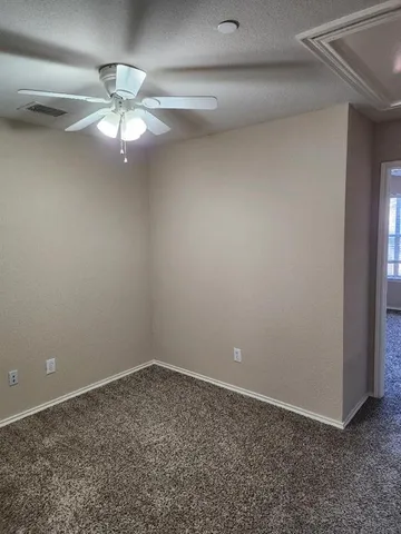 en empty room with windows and fan