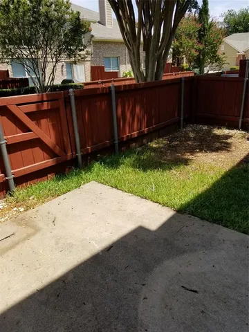 a view of a backyard with wooden fence