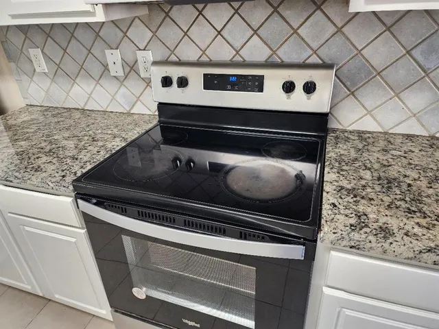 a stove top oven sitting inside of a kitchen