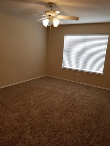 en empty room with windows and fan