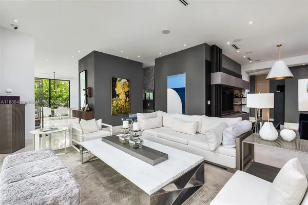 a living room with furniture a large window and a dining table with wooden floor