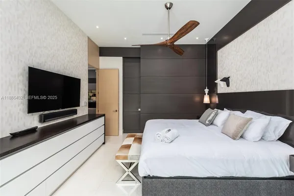 a bedroom with a bed and a flat screen tv