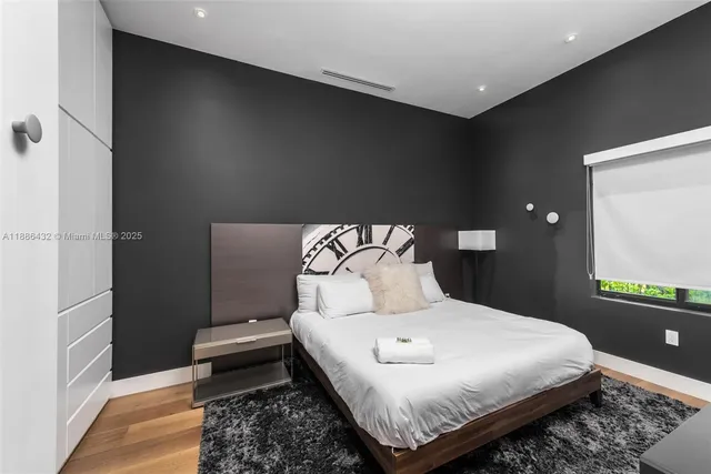 a bedroom with a bed and a dresser with mirror